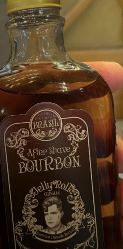 Frasco de after shave Bourbon da Jelly Roll na mão do barbeiro